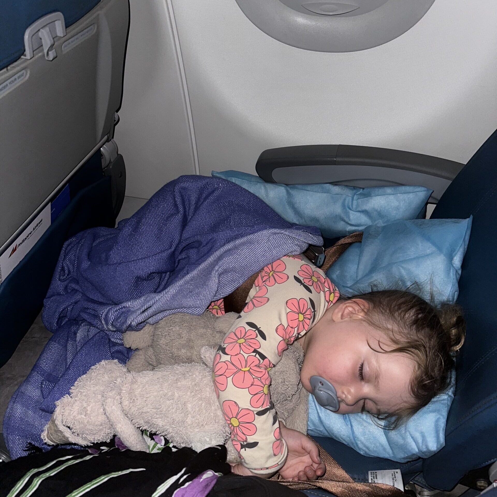 Traveling to Bali with Kids: Hailey peacefully sleeping on the Kooshy Kids kooshion, with tips for preventing ear popping during flights.