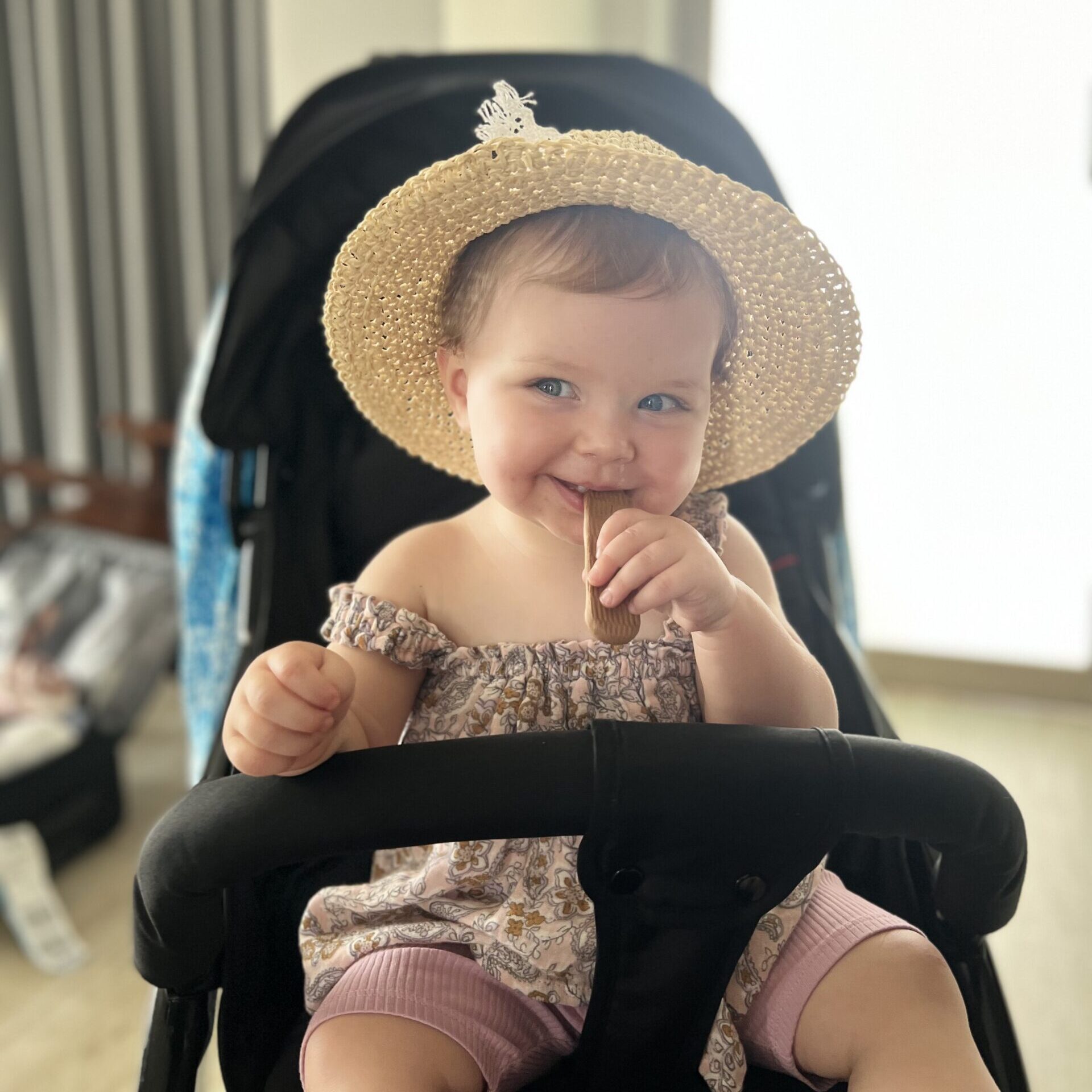 Hailey enjoying a snack and smiling in her pram during her first overseas trip to Bali at 16 months old. Traveling to Bali with Kids