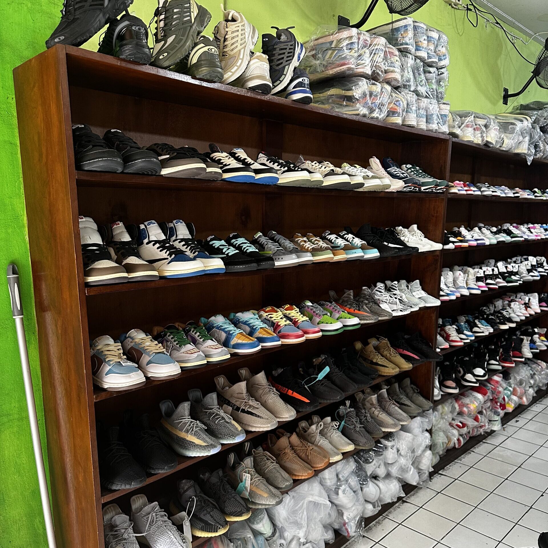A colourful display of various shoes in a trendy shoe store located in Seminyak, Bali, showcasing local styles and designs.