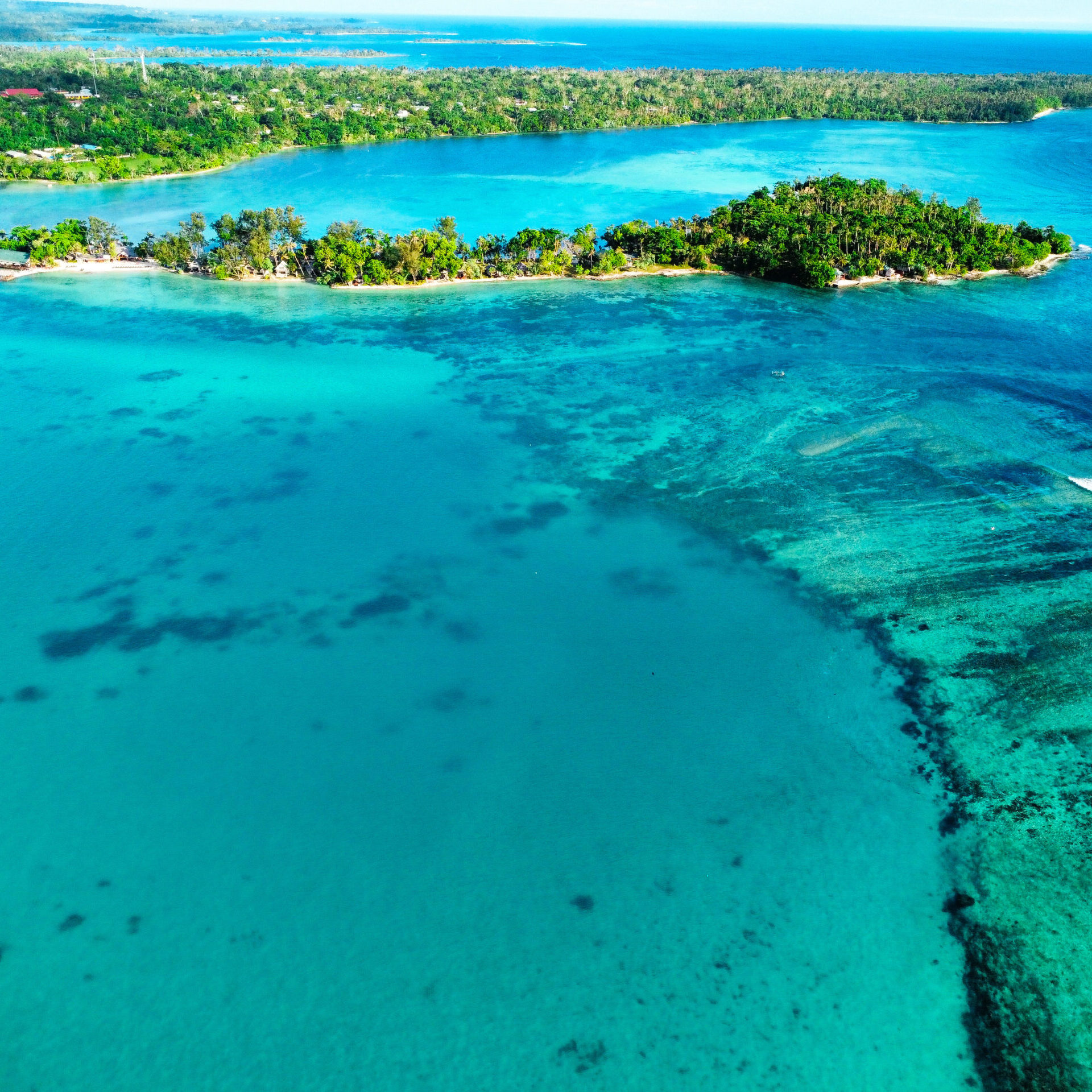A stunning drone shot capturing the vibrant reefs of Vanuatu in Port Vila, showcasing the natural beauty that travelers can explore while considering entry requirements: things you need to know.