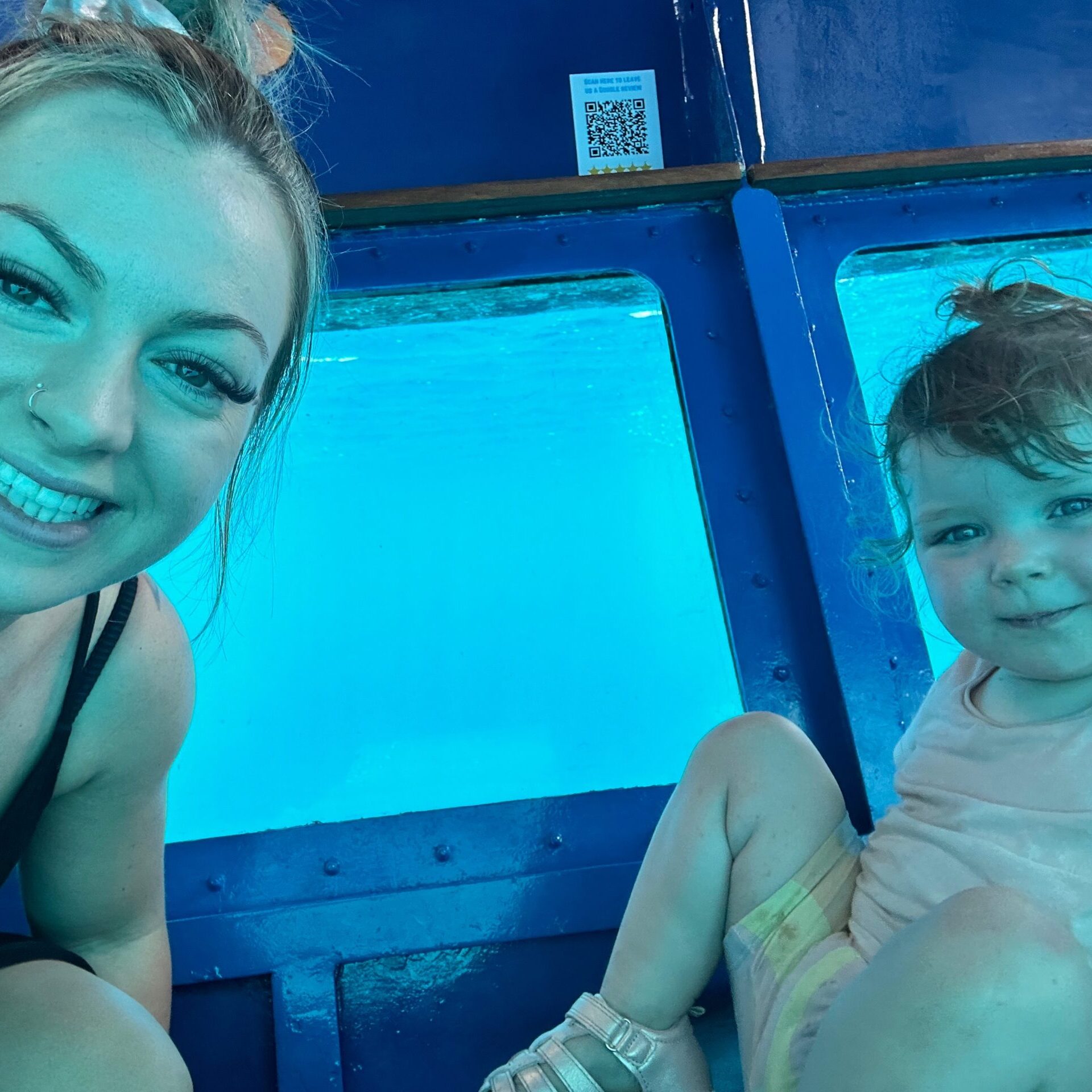 A mother and daughter in a transparent-bottom boat, exploring the underwater beauty in Vanuatu while learning about entry requirements: things you need to know